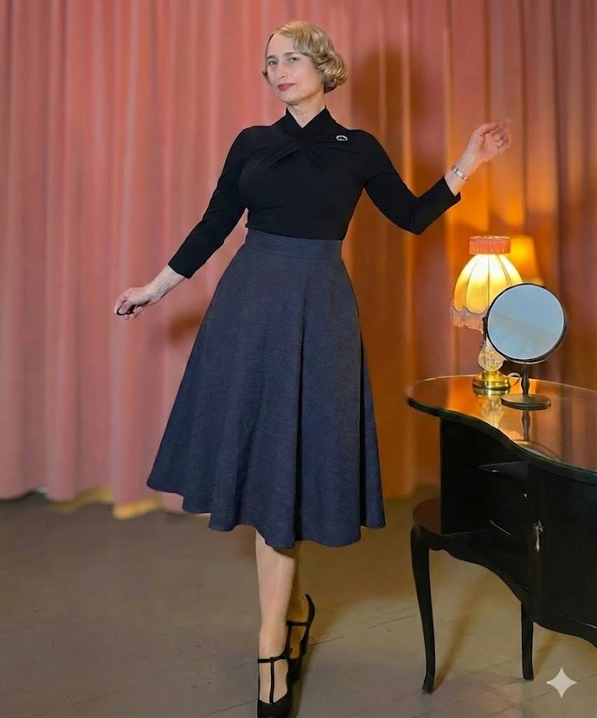 Model trägt einen klassischen Vintage Tellerrock in Schwarz mit Seitentaschen und hoher Taille, kombiniert mit einem eleganten Oberteil im 50er-Jahre-Stil.