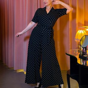 Schwarzer Jumpsuit mit weißen Punkten, Wickeloberteil und weitem Bein an einem Modell.