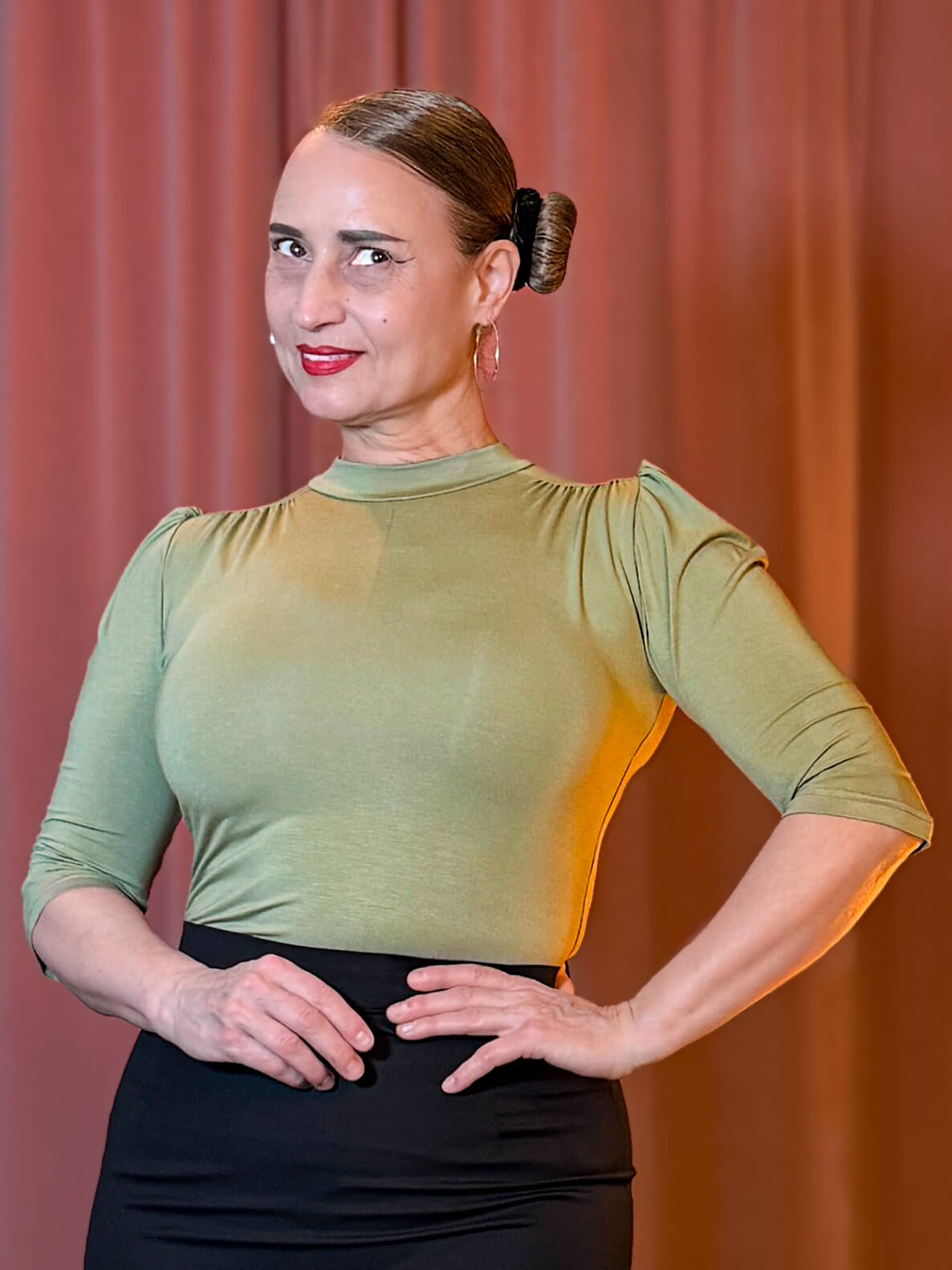 Frau trägt das lindgrüne Hazel Shirt mit Stehkragen und Dreiviertelärmeln zu einem dunklen Rock.