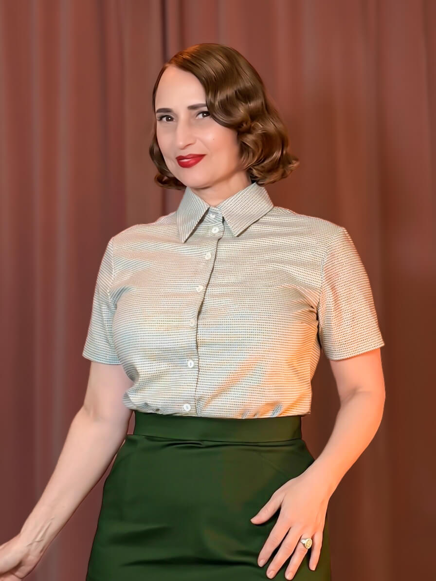 Frau im Vintage-Stil der 50er Jahre trägt die kurzärmelige, gemusterte Bluse Barbara in Grau-Blau mit Umlegekragen.