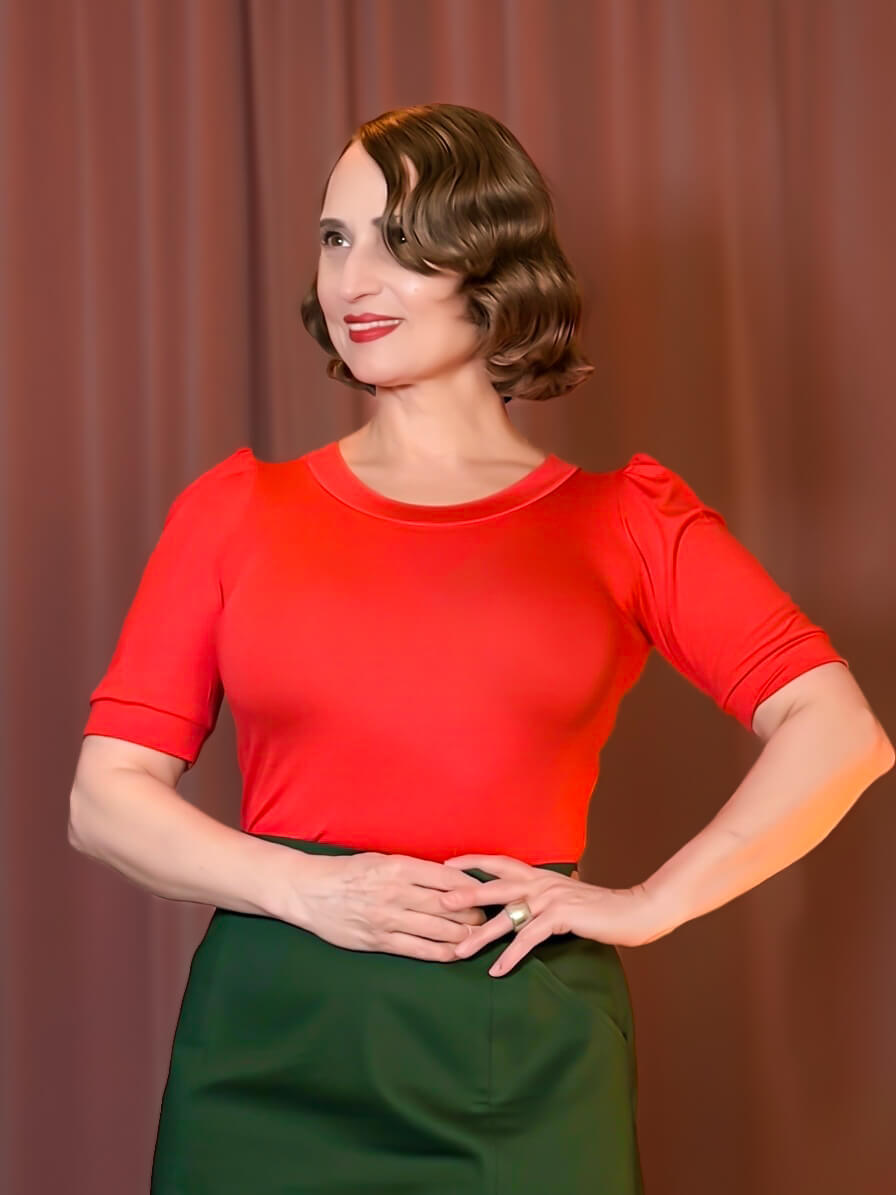 Rotes Diana Shirt mit Puffärmeln im Vintage-Stil der 40er Jahre, kombiniert mit dunkelgrünem High-Waist Rock.
