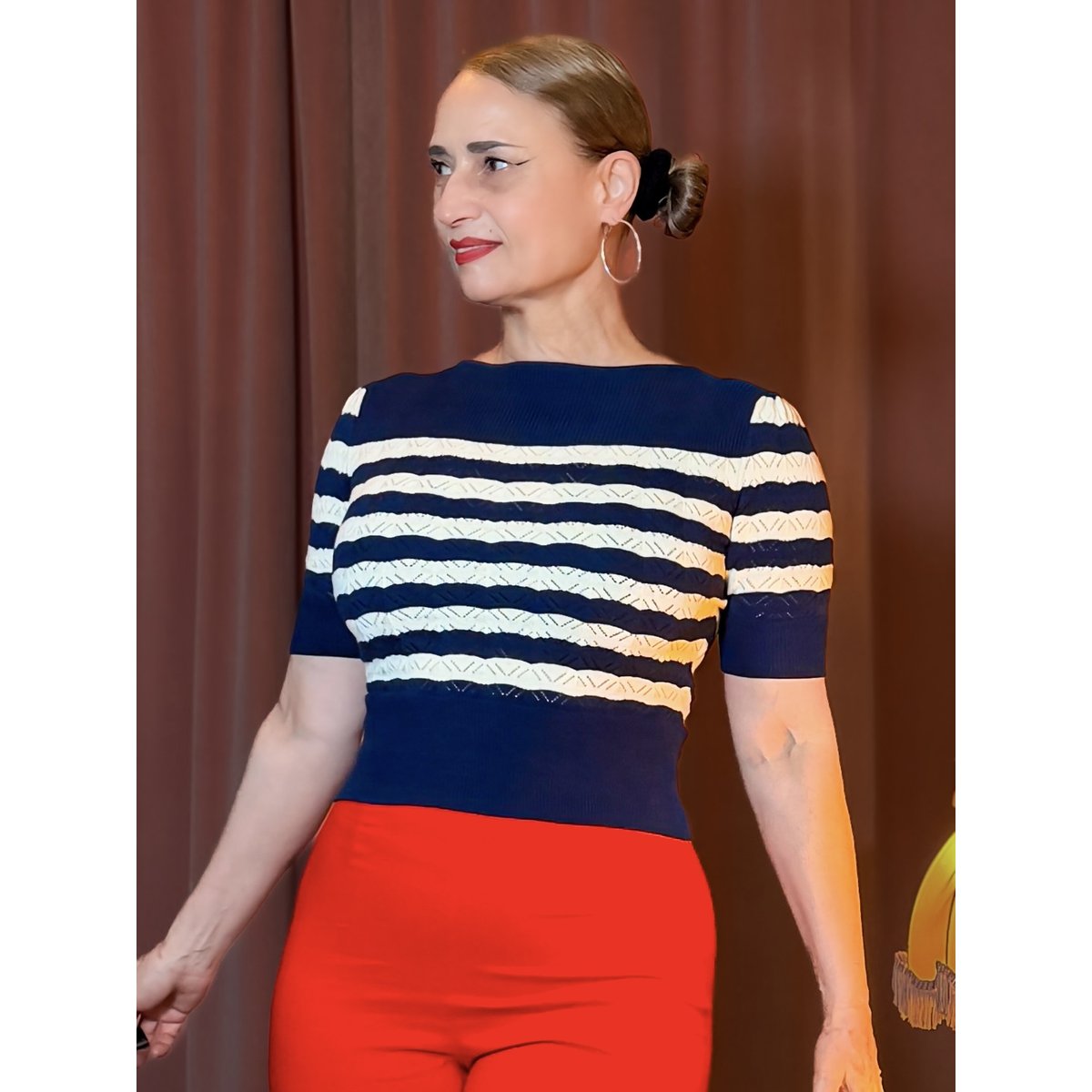 Eleganter navy-blauer Strickpullover mit cremefarbenen Streifen im 40er-Jahre-Stil, figurbetont geschnitten und kombiniert mit einer leuchtend orangefarbenen High-Waist-Hose für einen stilvollen Retro-Look – Hazel's Boudoir