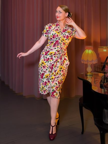 Elegantes Mable Dress im 40er-Jahre-Stil mit farbenprächtigem Wildblumenmuster in Pink und Gelb auf cremefarbenem Grund, figurbetonter Schnitt mit V-Ausschnitt und kurzen Ärmeln, perfekt für einen sommerlichen Swing-Abend – Hazel's Boudoir